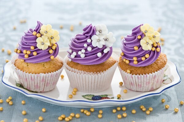 Muffins with violet cream and flowers