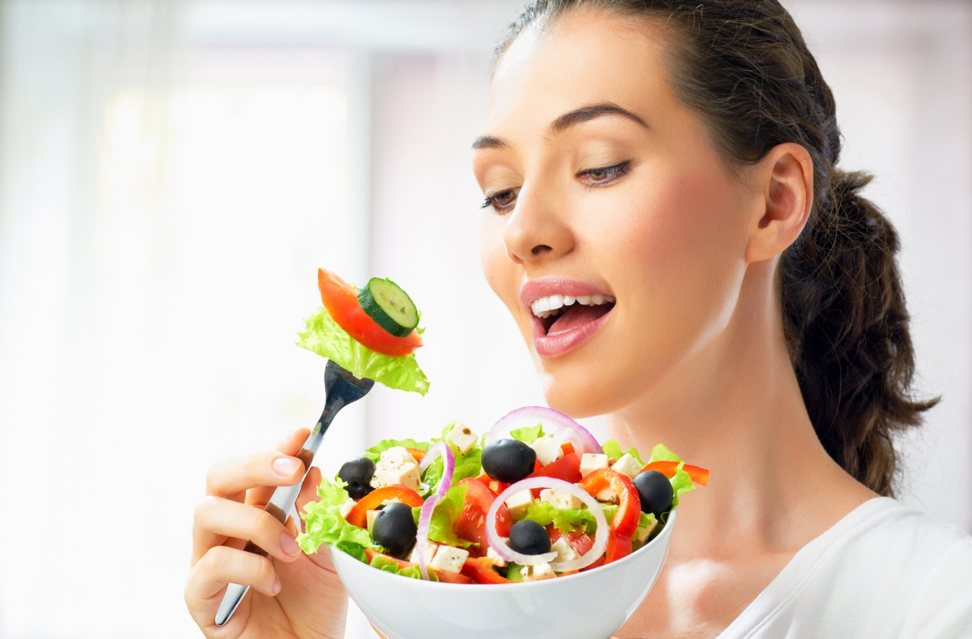 chica pelo castaño plato tenedor ensalada verduras encanto pepinos aceitunas cebolla queso tomates