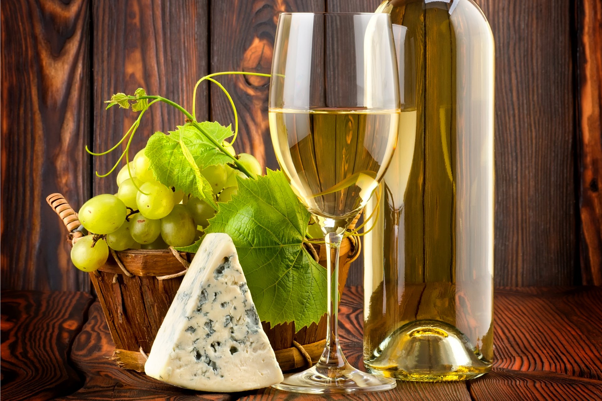 table a bottle wine white glass vine leaves grapes cheese