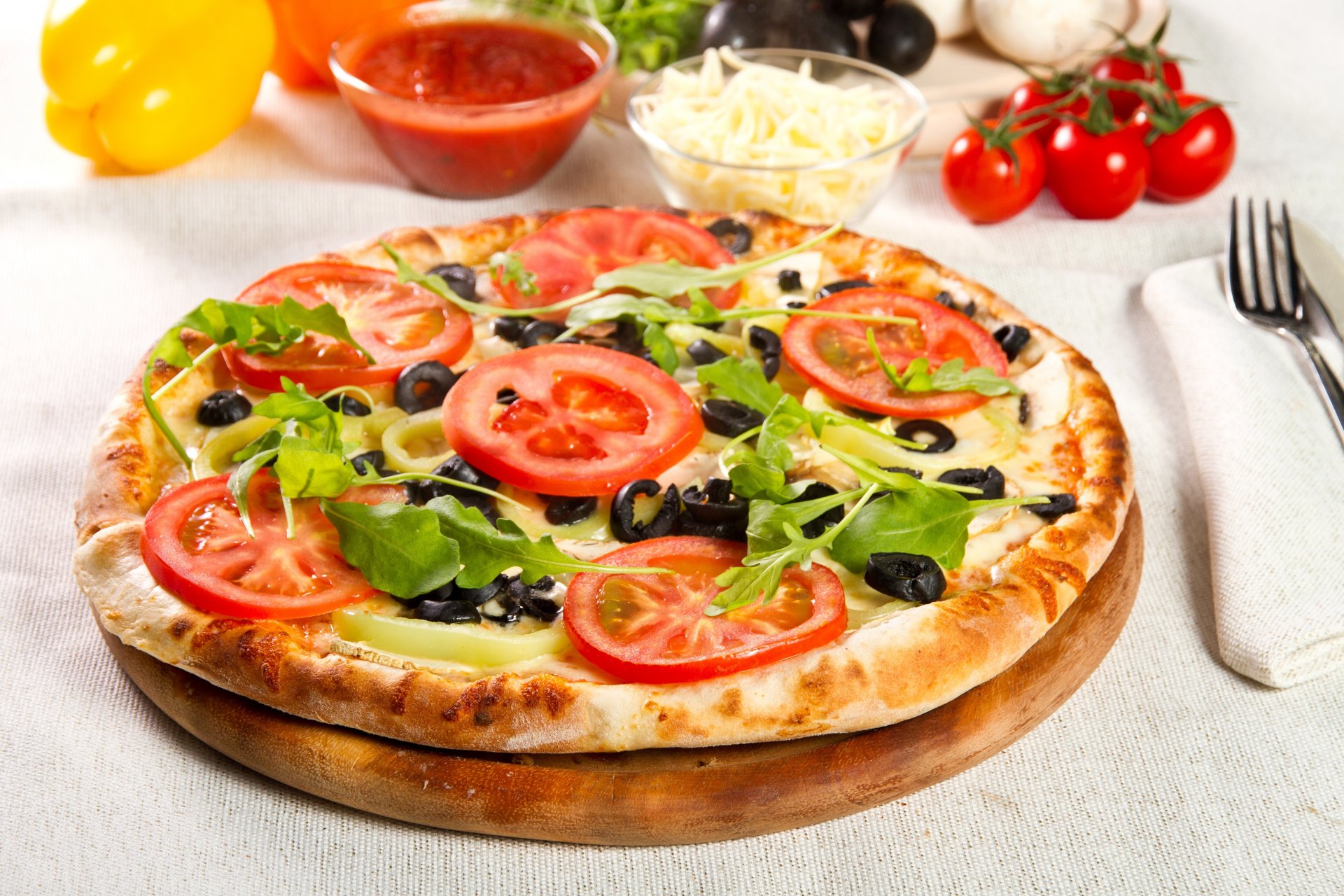 pizza dish tomatoes pepper cheese olives vegetables green food fork napkin