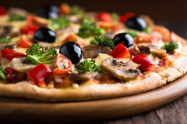 Pizza mit Pilzen, Oliven, Tomaten und Petersilie