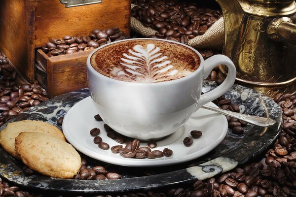 A cup of coffee standing on a tray with cookies