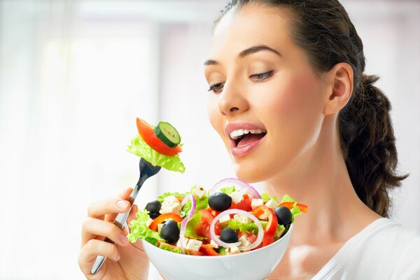 Adorable brunette avec une assiette de salade