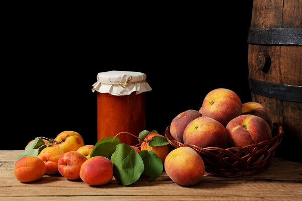 Still life of apricots, peaches, jam and a wooden barrel