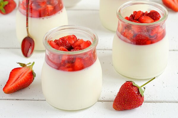 Strawberries and cream in transparent jars