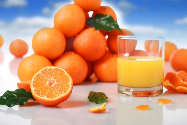 Orange juice and a mountain of juicy oranges