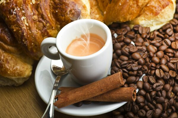 Espresso mit Zimtstangen und Kaffeebohnen