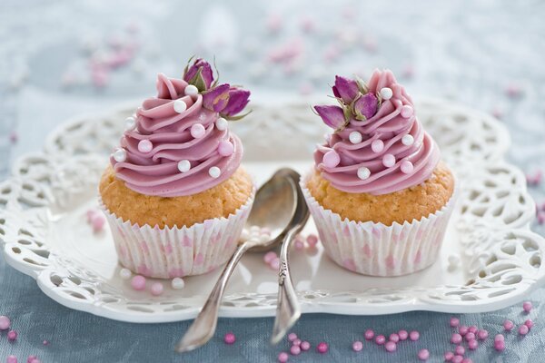 Two cupcakes with pink decor on a plate