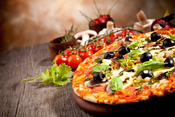 Pizza mit Oliven auf einem Holztisch