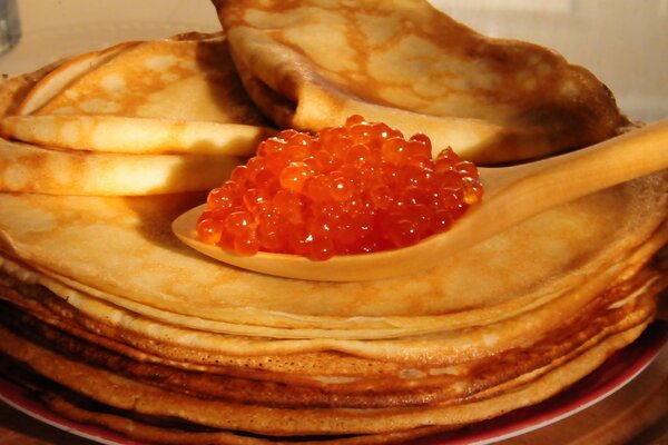 Crepes de color rojizo con caviar rojo granulado