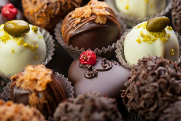 Dark chocolate candies decorated with berries and pistachios