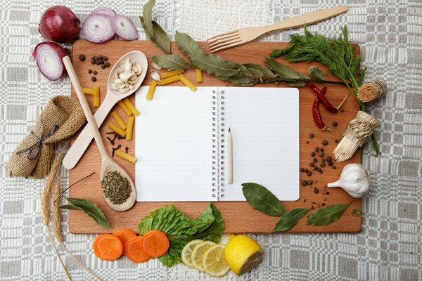 Carnet entouré de verdure, de légumes et d appareils