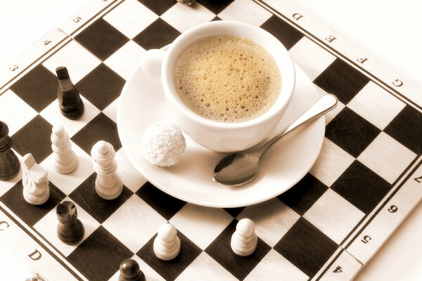 Coffee with Raffaello candy on a chessboard