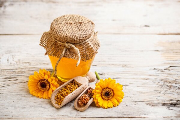 A jar of honey with a spoon in which seasonings