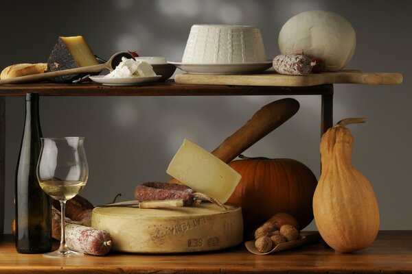 Autumn still life with pumpkin, wine, cheese and nuts