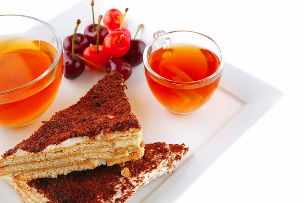 Cake with tea and cherries on a tray