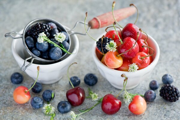 Moras y cerezas en tazones blancos