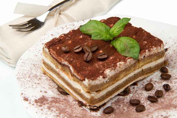 Tiramisu dessert on a plate. Decorated with coffee beans