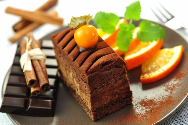 Serving dessert with orange, dark chocolate and cinnamon on a plate