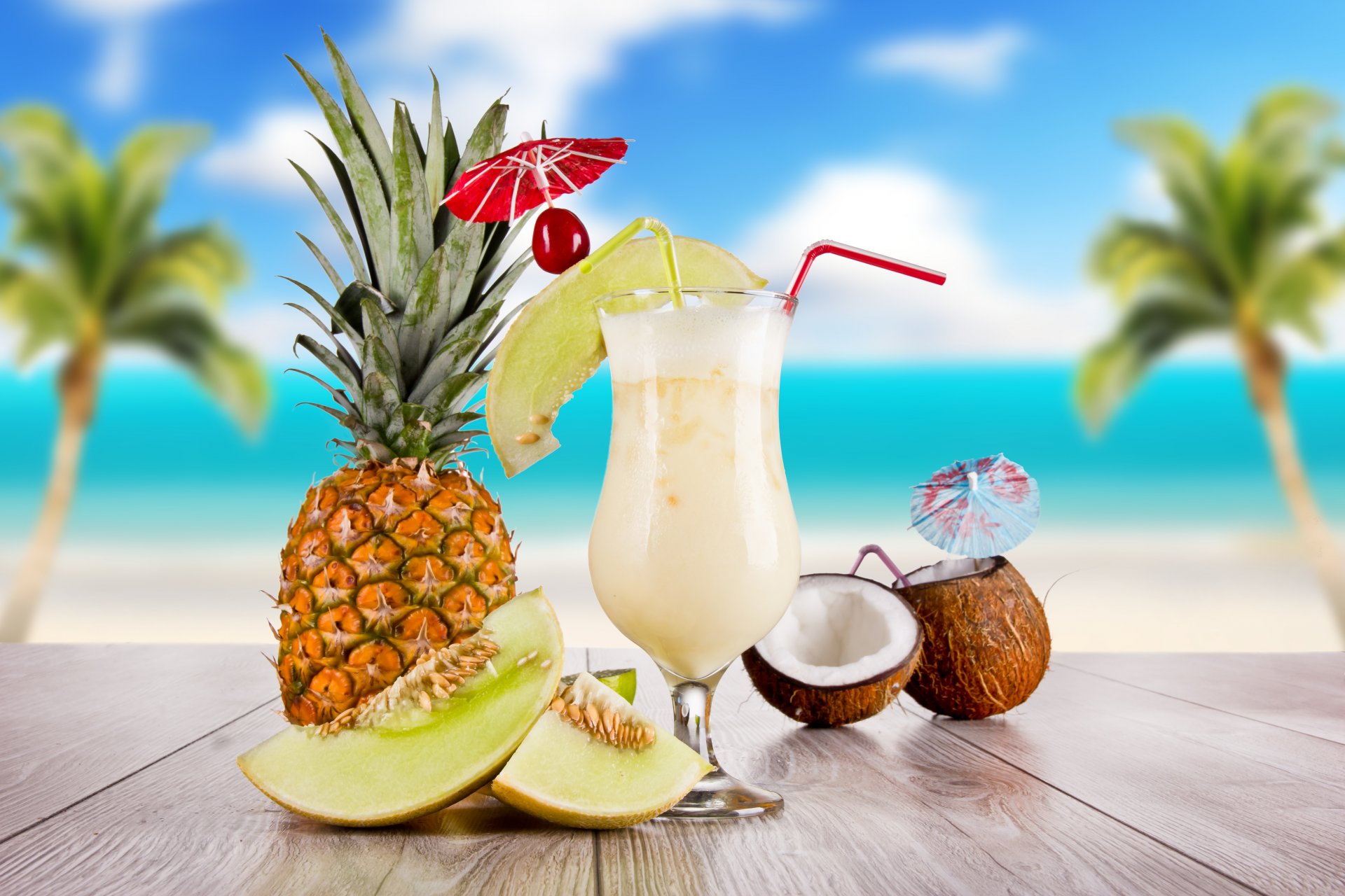 ummer food cocktail glass coconut pineapple table sky clouds palm sea tube skewer cherry