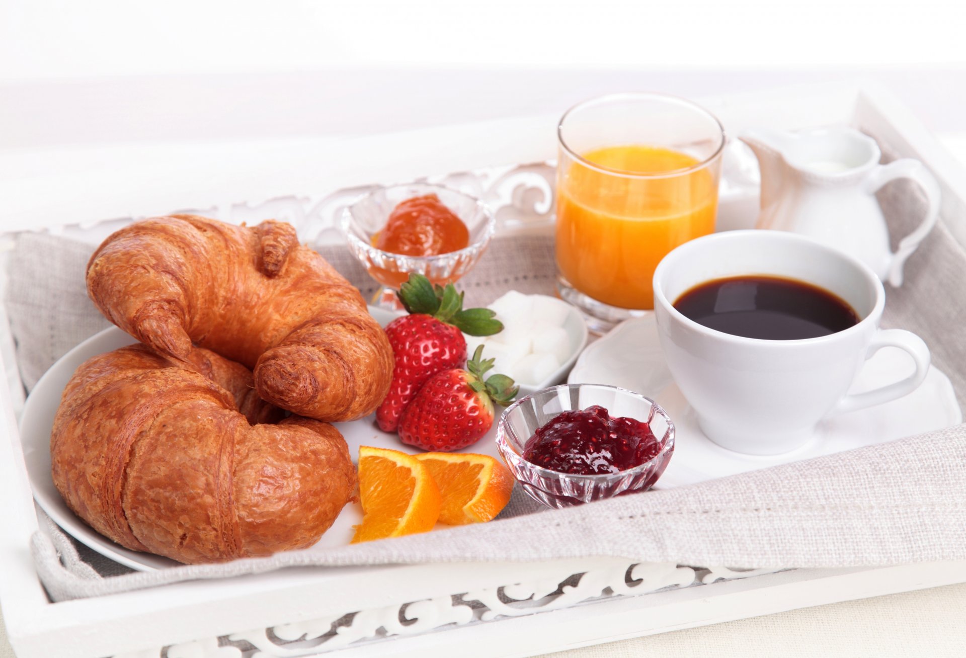 breakfast croissants bagels juice jam coffee strawberry orange segments cup glass sugar