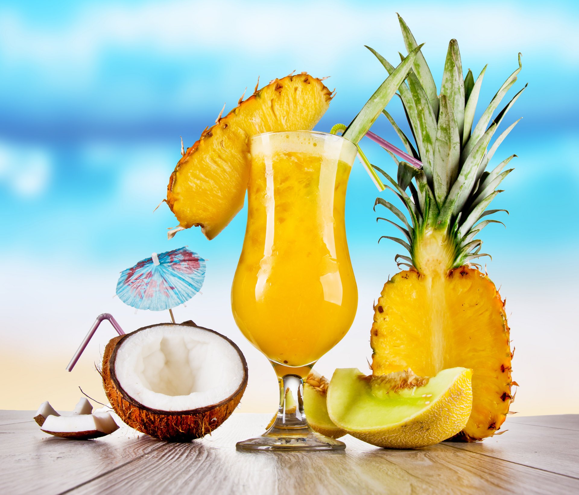 im sommer essen cocktails obst weingläser cocktail röhrchen spieße tisch ananas kokosnuss himmel