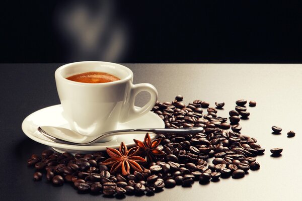 A white cup and coffee beans scattered on the table