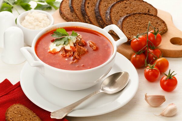 Borscht with sour cream, slices of rye bread and garlic