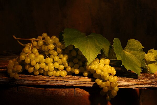 Bunches of grapes with leaves on the table