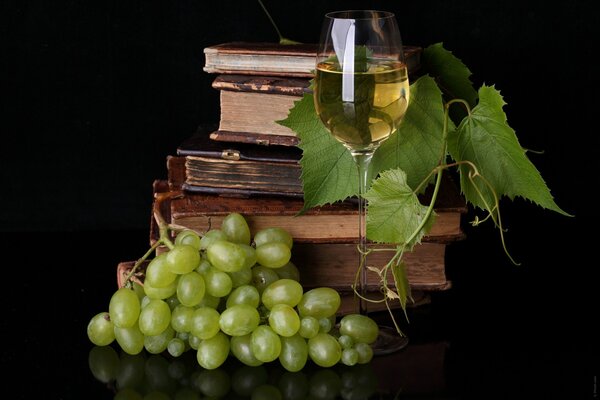 Bicchiere di vino bianco e pila di libri