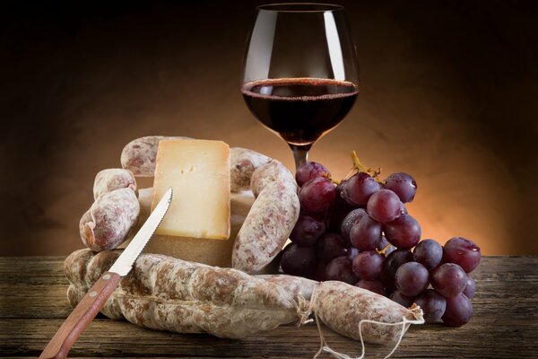 Immagine di vino rosso, uva, formaggio e salame