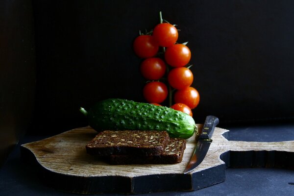 Schwarzbrot mit Gurken und Tomaten auf einem Brett