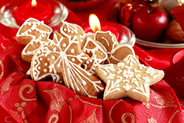 Christmas cookies, candles and apples on a red napkin