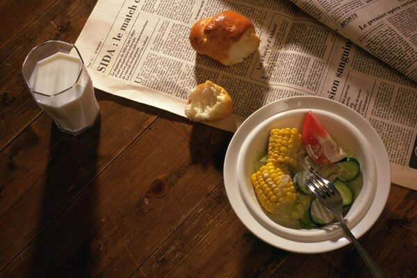 Naschen Salat, Milch und eine Zeitung in der Nähe