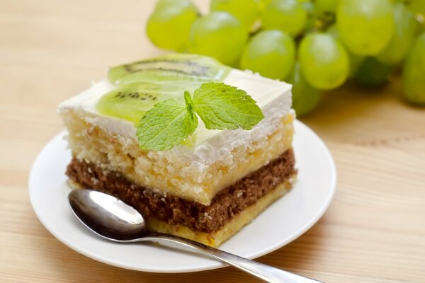 A piece of cake on a saucer with a mint leaf