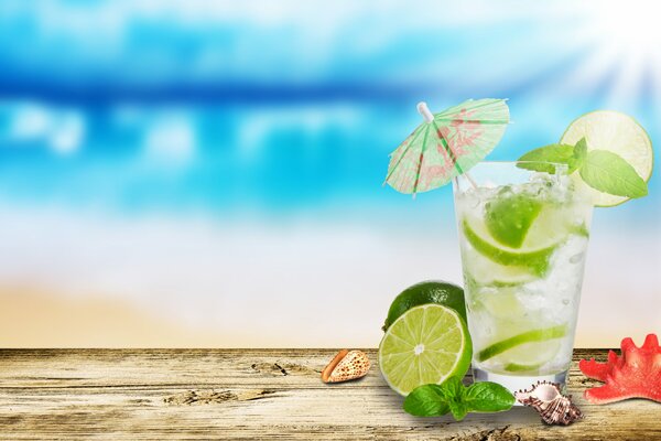 Mojito con lime in un bicchiere su sfondo blu