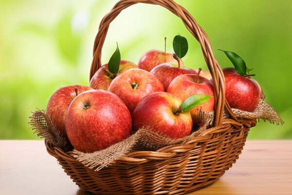 Panier en osier avec pommes rouges sur la table