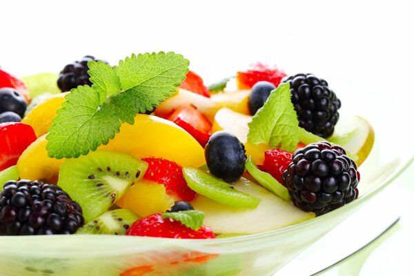 Fruit and berry salad decorated with mint sprigs