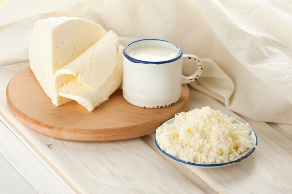 Mug with milk and cheese on a saucer