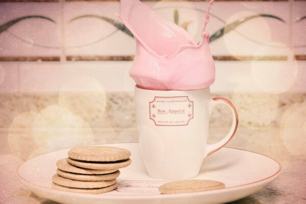 A soft pink cocktail in a mug with cookies for breakfast