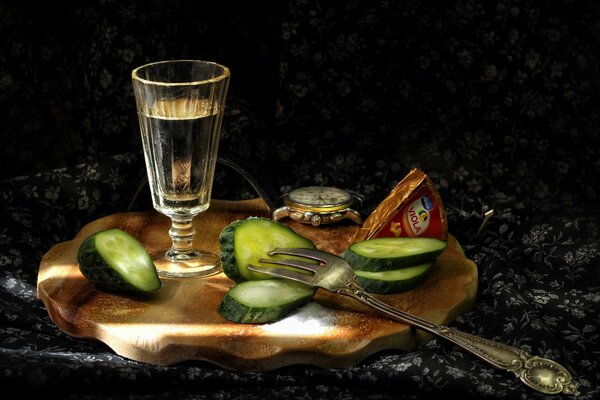 Un bicchierino di vodka con uno spuntino al cetriolo sul tavolo
