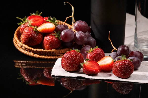 Strawberries with grapes on the table