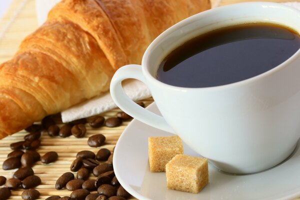 Café en taza y croissant con mermelada para el Desayuno