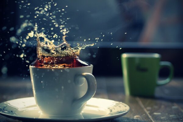 Splashes in a white cup of tea