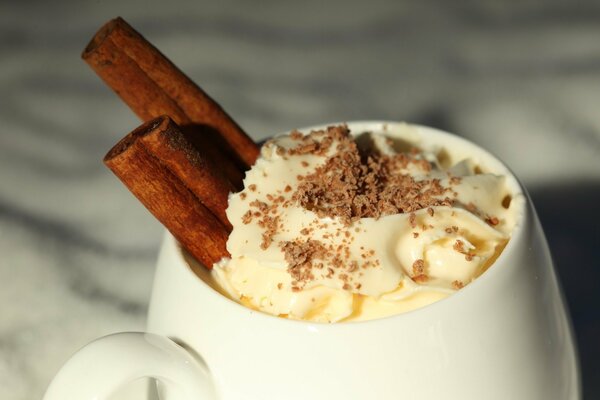 Tazza con bevanda calda decorata con panna e cioccolato grattugiato