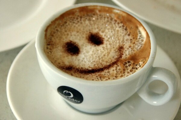 Souriant smiley café dans une tasse blanche