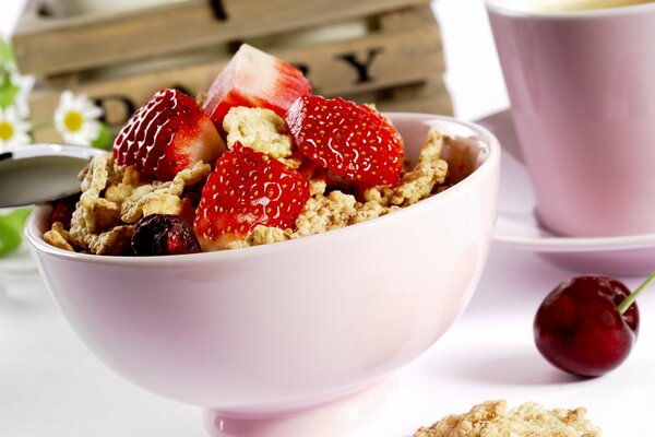 Postre dulce con fresas y cerezas en un plato rosa