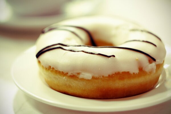 Donut in cremiger Glasur auf einer Untertasse