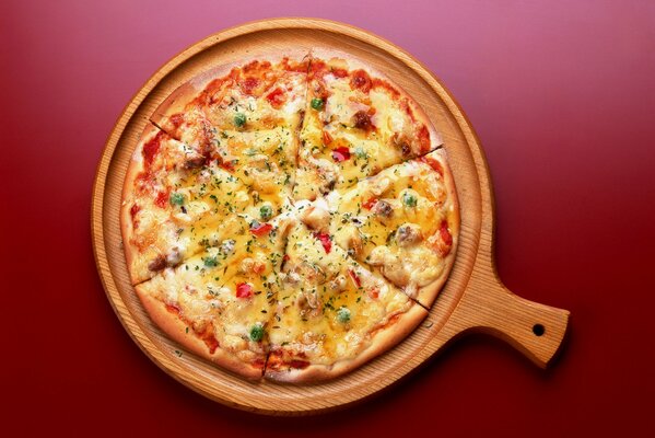 Delicious pizza on a wooden tray , on a red table