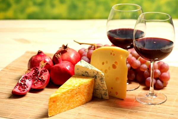 Teller mit Käse, Obst und Wein
